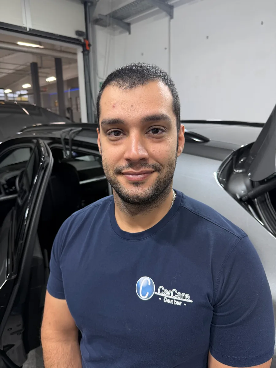 Eshan in der Halle vor Fahrzeugen mit geöffneten Türen